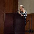 woman at podium speaks to crowd